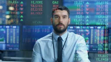 Borsa en iyi tüccar öngörülen Ticker numaraları ve grafikler çalıştıran, analiz veri en iyi yapmak için satmak görünüyor. Onun arkasında ekranlar ve istatistik dolu Oda.
