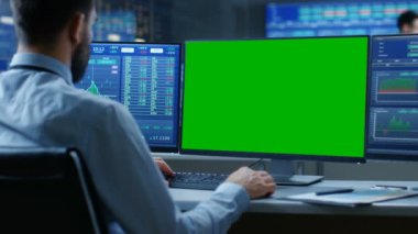 Borsa tüccar bir bilgisayarla iletişim izole Mock-up çalışma omuz görünümü üzerinde senedi grafikleriyle yeşil ekran ve ikinci görüntü gösteren sayı. İlgili bilgileri arka plan monitörlerle.