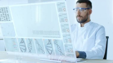 Fütüristik laboratuvarda erkek bilim Works deşifre Dna üzerinde onun şeffaf bilgisayar ekranda sıra..