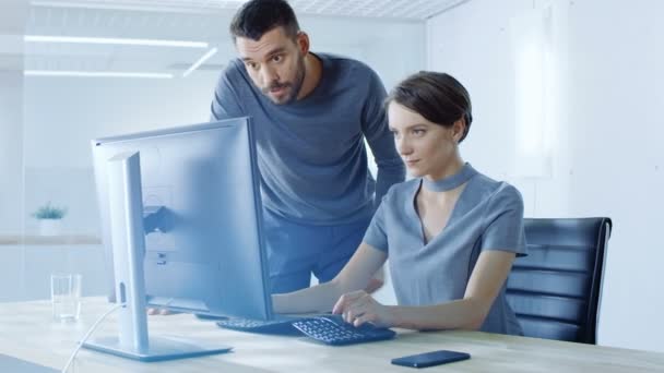 男性和女性办公室工作人员讨论个人计算机上显示的信息 办公室现代明亮 — 图库视频影像