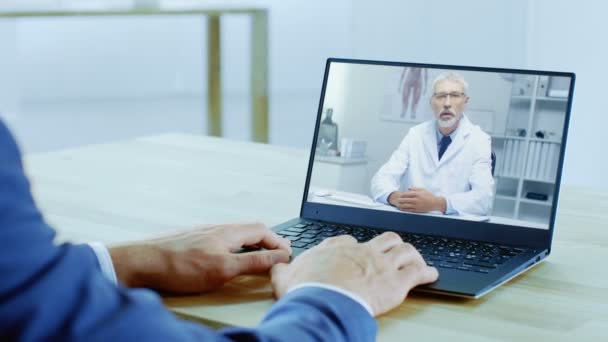 接近的商人与他的医生进行视频通话 人使用笔记本电脑 — 图库视频影像