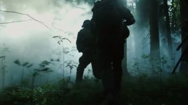 Tam donanımlı asker, düşman saldıran kamuflaj üniforma tüfek ateş için hazır. Eylem, yoğun Smokey orman yoluyla oluşumunda çalışan kadrosu askeri operasyon.