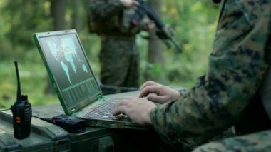 Aksiyon, uluslararası görevi gerçekleştirmek için askeri düzeyde Laptop kullanım askeri sanayi kompleksi donanım kullanarak asker askeri operasyonda. Arka plan kamufle çadırda ormanda.