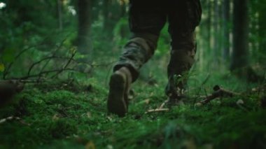 Yakın çekim grup daha fazla yoğun orman hamle Moss üzerinde adım Asker botları donanımlı. İnanmadılar askeri göreve dağıtmadan. Düşük açılı görüntüleri.
