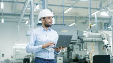 Hard Hat 'te Baş Mühendis Dizüstü bilgisayar tutarken Modern Fabrika' da Dolaşıyor. Başarılı, Modern Endüstriyel Çevrede Yakışıklı Adam.