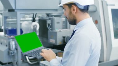 Baret inşaat üstünde yeşil Mock-up ekran Laptop Modern elektronik fabrika üretim ortasında dururken endüstri mühendisi.