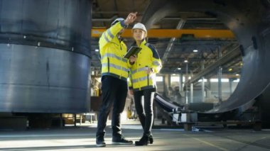 Erkek ve kadın Endüstri mühendisleri da zor şapka tartışmak yeni proje ise Tablet bilgisayar kullanarak. Onlar ağır sanayi Gestures.They çalışmaları gösteren fabrika üretim yapmak. Ufak bir olasılık.