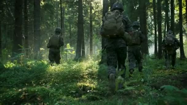 装备精良的士兵身穿迷彩制服攻击敌人 步枪准备射击 军事行动 小队通过茂密的烟熏森林在编队中奔跑 后退视图慢动作素材 — 图库视频影像
