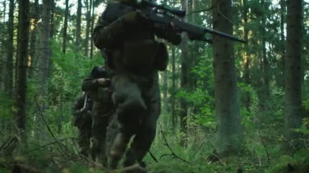 敵を攻撃している迷彩服を着て完全装備の兵士ライフルは 撮影する準備が整いました アクション スモーキーの鬱蒼とした森を形成中の分隊で作戦 スローモーション — ストック動画