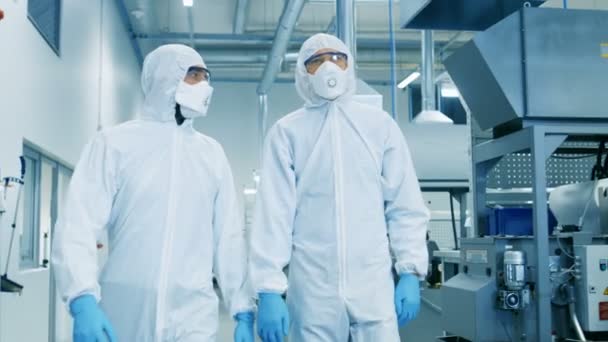 Zwei Ingenieure Wissenschaftler Sterilen Schutzanzügen Die Durch Technologisch Fortgeschrittene Fabrik — Stockvideo