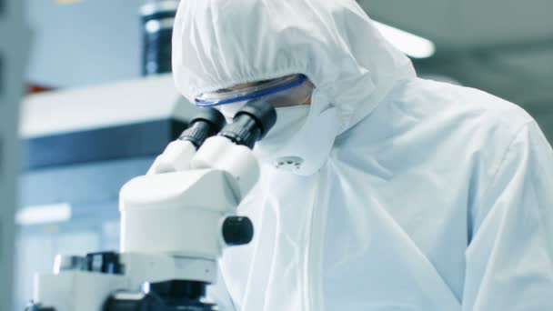显微镜下的工程师 技术员 科学家检查组件的特写 他在工作项目时穿着无菌工作服和防护眼镜 — 图库视频影像