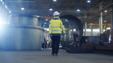 Ağır fabrika çeşitli metal işleme süreçleri ile imalat sanayi endüstri mühendisi baret Emanet ceketin içinde yürür.