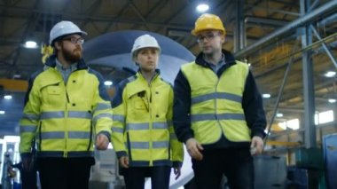 Atış üç mühendisleri ağır sanayi ile fabrika imalatı yürüyen takip. Yapım aşamasında, çeşitli metal işleri, boru hattı kaynak arka planda / varil bileşenleri. Ağır çekim.