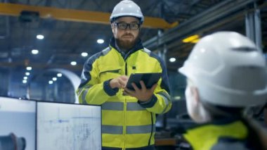 Ağır Sanayi Fabrika içinde kadın mühendis çalışıyor kişisel bilgisayarınızda o 3d motor modeli, onun erkek arkadaşı onunla konuşur ve Tablet bilgisayar kullanır tasarımlar.