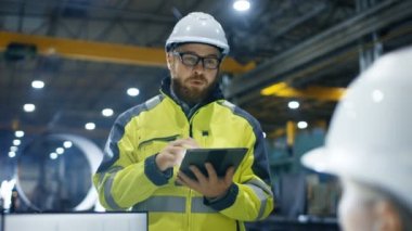 Ağır Sanayi Fabrika içinde kadın mühendis çalışıyor kişisel bilgisayarınızda o 3d motor modeli, onun erkek arkadaşı onunla konuşur ve Tablet bilgisayar kullanır tasarımlar.