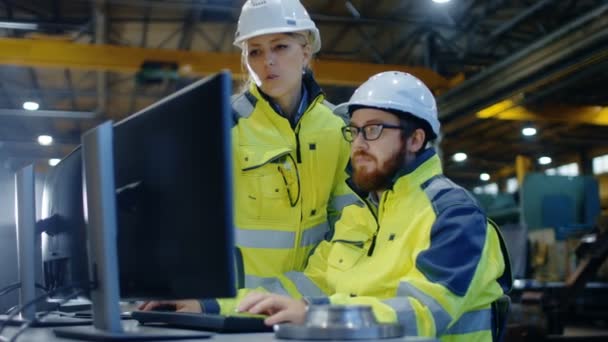 男工业工程师在个人电脑上工作 女经理谈论项目 他们在重工业制造厂工作 — 图库视频影像