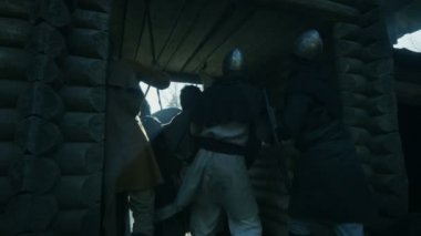 Ortaçağ köylüler Viking saldırısından saklamaya tahta kale kapıları Through git. Muhafızlar masum insanları savunmak. Withing Hillfort görüntüleri. Ortaçağ canlandırma.