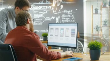 İki erkek mobil oyun uygulama geliştiricileri bir kişisel bilgisayarda tasarımı Wireframe çalışırken konuşmak. Yaratıcı Indie stüdyo, iş arkadaşları eser.