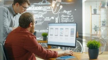 İki erkek mobil oyun uygulama geliştiricileri bir kişisel bilgisayarda tasarımı Wireframe çalışırken konuşmak. Yaratıcı Indie stüdyo, iş arkadaşları eser.