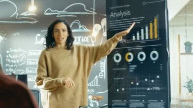 Erkek proje yöneticisi tutan toplantı istatistiksel grafikler ve etkileşimli beyaz tahta Touchscreen aygıt üzerinde gösterir. O şık yaratıcı kurumunda çalışıyor.
