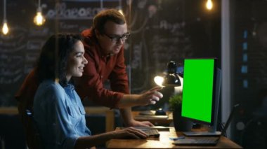 Her Danışma müzakerelerinde Her erkek Mock-up yeşil ekran bilgisayar üzerinde çalışırken iş arkadaşınız ile güzel kadın ofis çalışanı. Yaratıcı akşam Office.