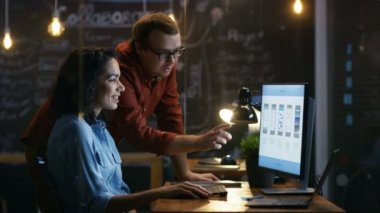 Güzel kadın mobil oyun uygulama geliştirici sohbetleri onun erkek arkadaşı ile onlar yaratıcı tasarım tartışmak. Şık aydınlatılmış Office.
