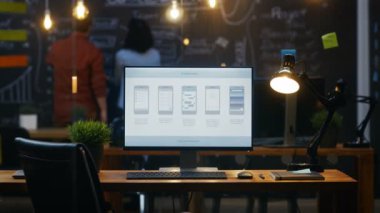 Ofis masasında, arka plan insanlar iş yaratıcı ofiste Blackboard duvara monitörde gösterilen mobil uygulama tasarımı ile kişisel bilgisayar standları.