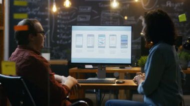 Güzel kadın mobil oyun uygulama geliştirici sohbetleri onun erkek arkadaşı ile onlar yaratıcı tasarım tartışmak. Şık aydınlatılmış Office.