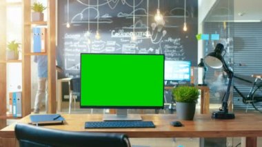 Kişisel bilgisayar Mock-up yeşil ekran monitör ofis masasında adam arka plan standları ile yaratıcı ofiste gündüz çalışıyor..
