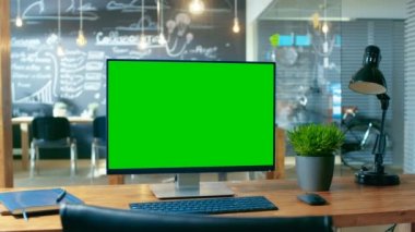 Mock-up yeşil ekran monitör ile kişisel bilgisayar Office masanın üzerinde duruyor. Gündüz, yaratıcı ofiste arka plan adam eserlerinde.