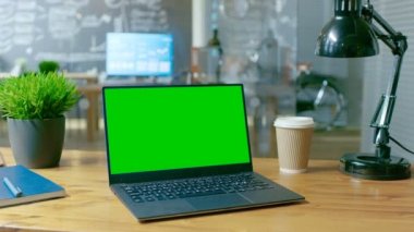 Mock-up yeşil ekran monitör ile kişisel bilgisayar Office masanın üzerinde duruyor. Arka plan şık yaratıcı ofiste içinde gündüz.