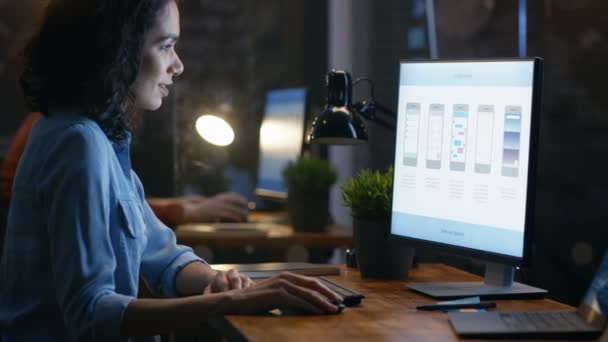 美しい女性モバイル ビデオ ゲーム アプリケーション開発者は パソコンの机で働いています バック グラウンドでクリエイティブ オフィスの同僚 — ストック動画
