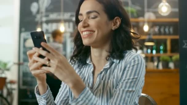 Hermosa Mujer Sienta Café Utiliza Smartphone Ella Sonríe Mientras Envía — Vídeos de Stock