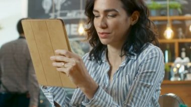 Güzel İspanyol kadın kullanır Tablet şık Cafe otururken bilgisayar.