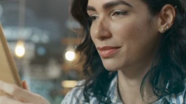 Güzel İspanyol kadın kullanır Tablet şık Cafe otururken bilgisayar portresi. O jestleri Swiping yapar.