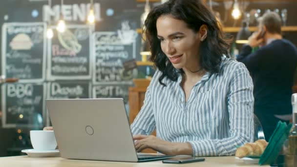 Jovem Mulher Atraente Trabalha Computador Portátil Enquanto Sentado Elegante Cafetaria — Vídeo de Stock