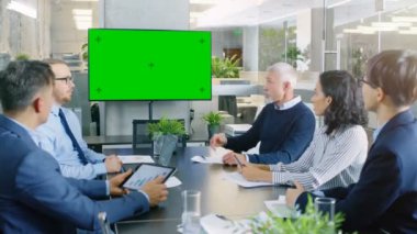 Farklı grup başarılı iş adamları yeşil ekran Chroma anahtar Tv duvar ile konferans odasında. Onlar bir şirketin büyüme, paylaşım grafikler ve istatistik iş.