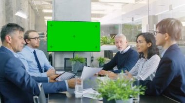 Farklı grup başarılı iş adamları yeşil ekran Chroma anahtar Tv duvar ile konferans odasında. Onlar bir şirketin büyüme, paylaşım grafikler ve istatistik iş.