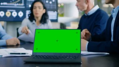 Yeşil Chroma anahtar ekranda Konferans masası ile Toplantı Oda Laptop. Arka plan iş adamları önemli tartışma var.