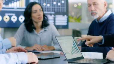 Toplantı odasında farklı grup iş adamları Laptop istatistiksel büyüme programında yanıt. Akıllı ve saygın insanlar.