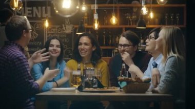 Farklı bir grup genç insan var eğlenceli Bar, söz, hikayeler ve şakalar söylüyorum. Çeşitli içki içiyorlar. Şık Hipster işyerinde onlar.
