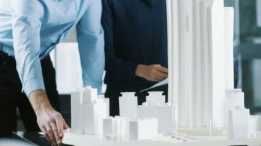 Erkek Kıdemli mühendis ve kadın mimari Tasarımcısı için kentsel tasarım projesi üzerinde bir bina modeli tasarım çalışması.