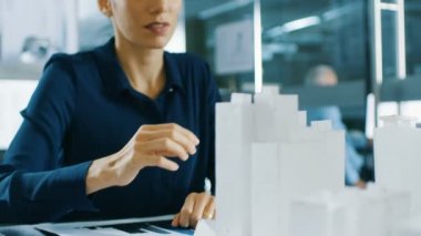 Kadın mimari Designer bileşeni bir bina modeline ekler, o bir şehir bölge kentsel planlama proje üzerinde çalışıyor. Güzel kadın şık ofis.