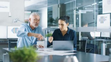 Deneyimli erkek ve kadın Endüstri mühendisleri tartışma, ayarlama yapma ve mükemmelleştirmek parçaları, türü düzeltmeler bir laptop, onlar iş makine bileşen tasarımı var.