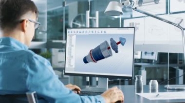 Tasarımı bir kişisel bilgisayarda çalışan otomotiv mühendisi Cad programında yeni verimli araba motoru. O parlak ve Modern ofis çalışıyor.