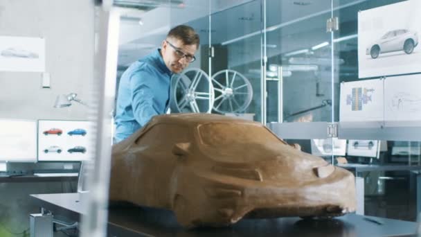 体验汽车设计师与耙造型原型车模型从橡皮泥粘土 他在一家大型汽车公司总部的现代化工作室工作 — 图库视频影像