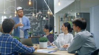 Karizmatik takım lideri bahsediyor ilerici mühendisleri ekibi ile yenilenebilir enerji, güneş paneli ekstra verimli prototip dayadı. Şık ofis ortamı yetenekli gençler.
