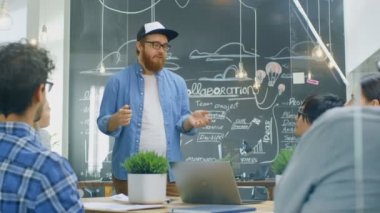 Karizmatik takım lideri Laptop yetenekli genç geliştiriciler farklı bir grup için gösterir, tartışma toplantı masasında başlarlar. Şık ofis ortamında yaratıcı insanlar.