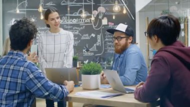Grup toplantısında konuşan, Şirket'in amacı, hırsları ve gelecekteki projeler tartışıyor kadın takım lideri. Modaya uygun Office ortamında yaratıcı genç geliştiriciler.