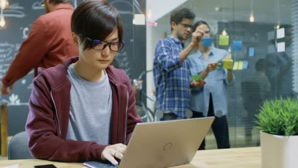 忙しいオフィスの創造的な人々 の完全でラップトップのテーブル作品で座っている才能のあるアジアの開発者 — ストック動画